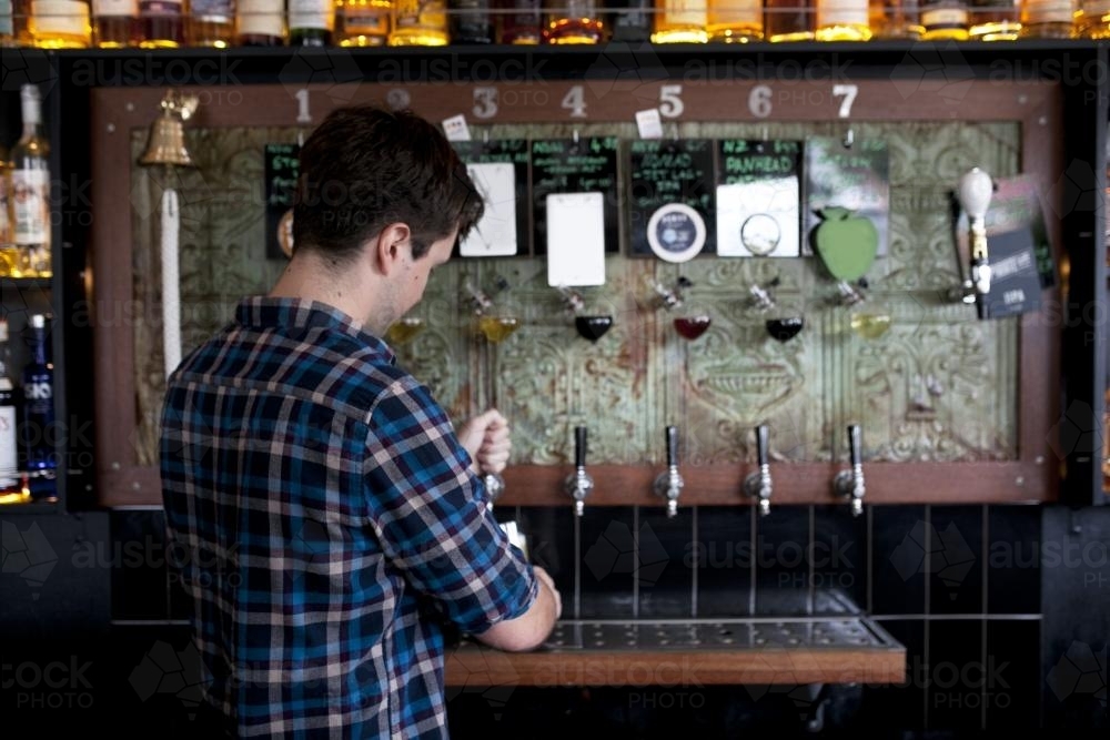 Bartender pouring a tap beer at a local craft beer bar - Australian Stock Image