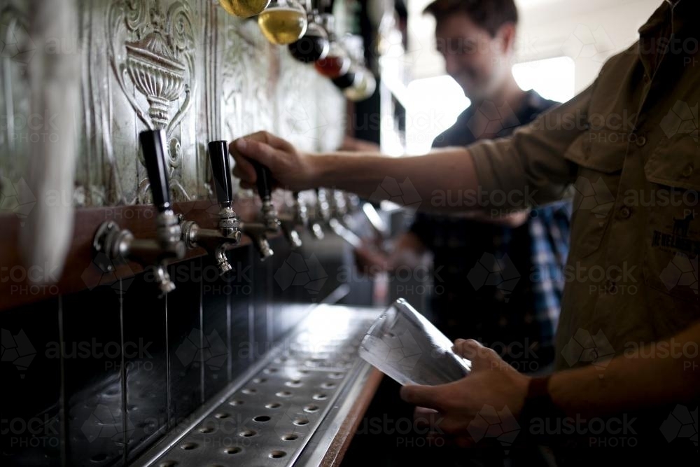 Bartenders pouring drinks at local craft beer bar - Australian Stock Image