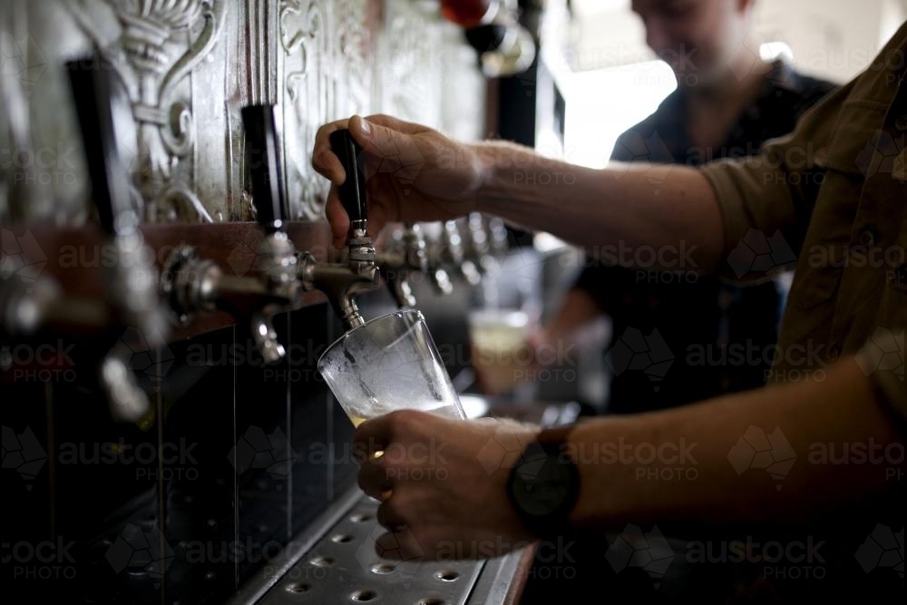 Image of Bartenders pouring drinks on tap at local craft beer bar