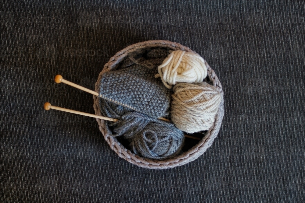 Basket of knitting, knitting needles and wool on grey background - Australian Stock Image