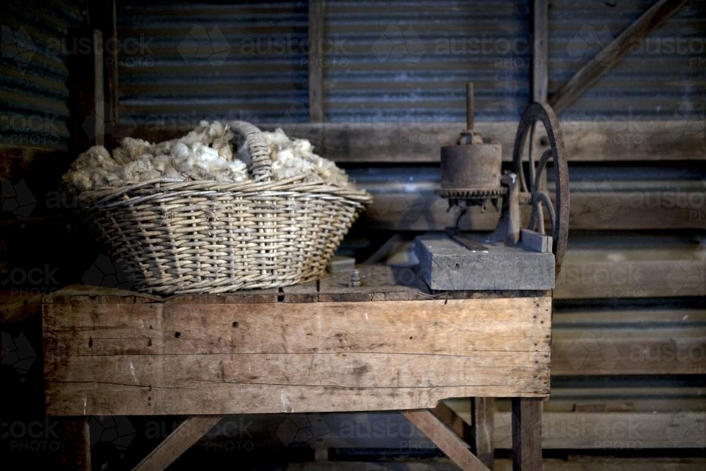 Basket of wool on old wooden table in farm shed - Australian Stock Image