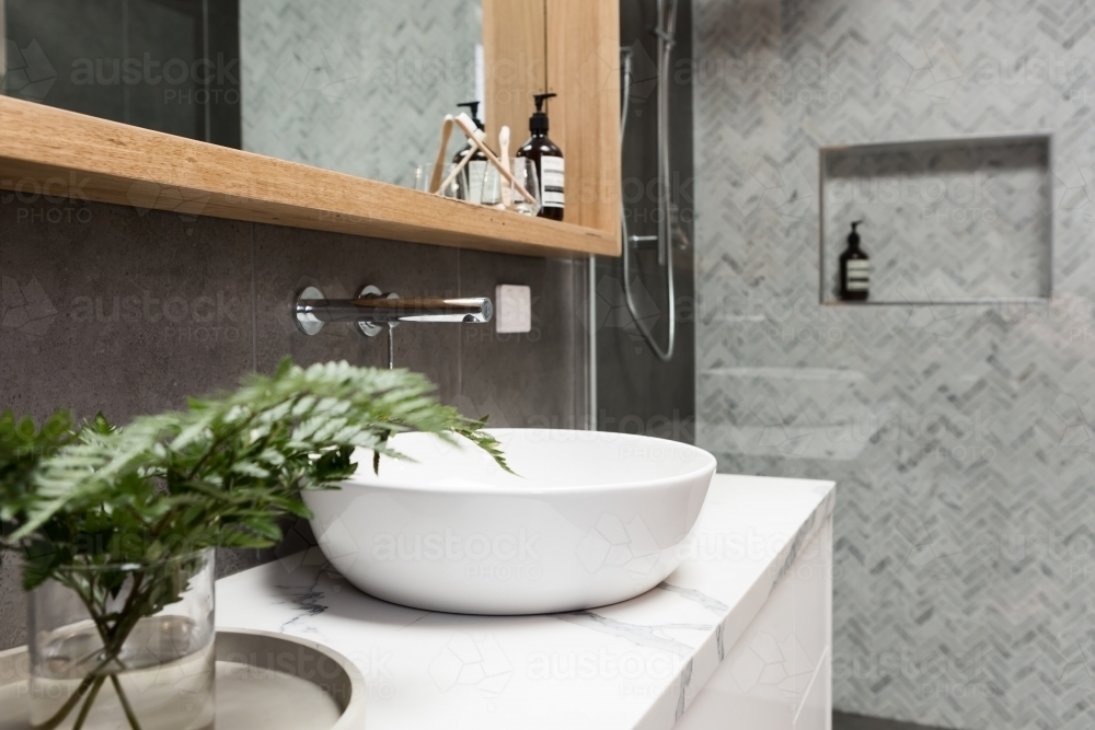 Bathroom details clean white basin with shower tiling behind - Australian Stock Image