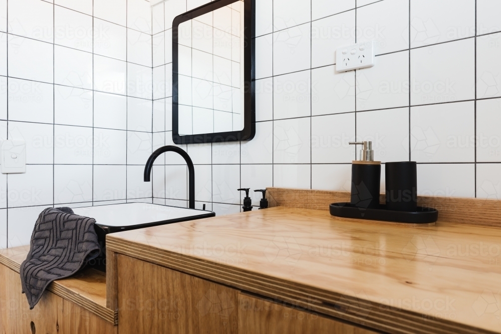 Bathroom vanity of wood with black basin and taps - Australian Stock Image