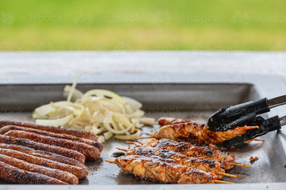 bbq sausages and chicken being cooked in park - Australian Stock Image