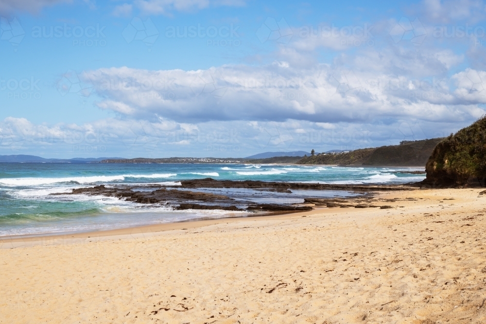 Beach cove with rocky shelf and waves - Australian Stock Image