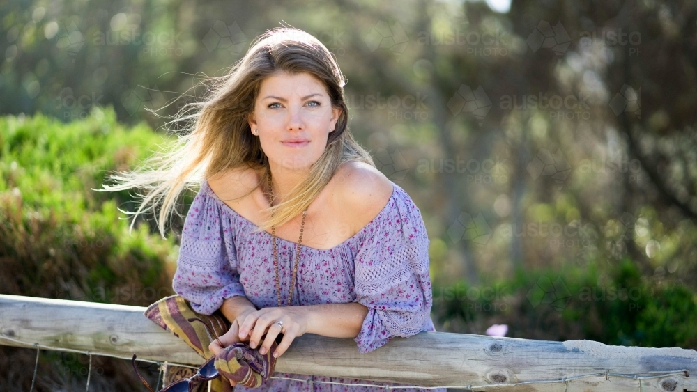 Beach girl leaning on wooden railing - Australian Stock Image