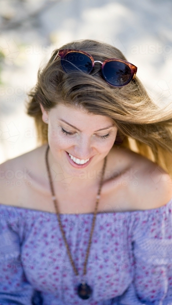 Beach girl shot from above sitting on sand - Australian Stock Image