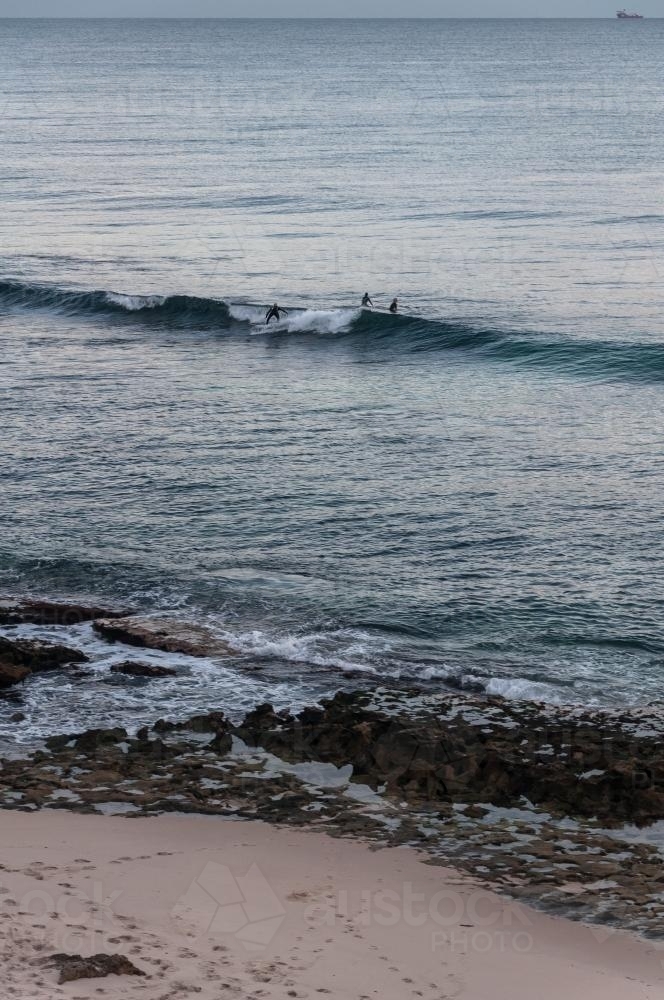 Beach landscape with surfers in distance - Australian Stock Image