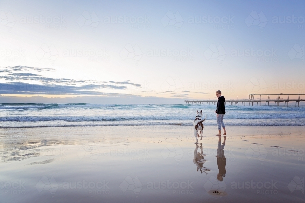 Beach reflections with boy & Dog - Australian Stock Image