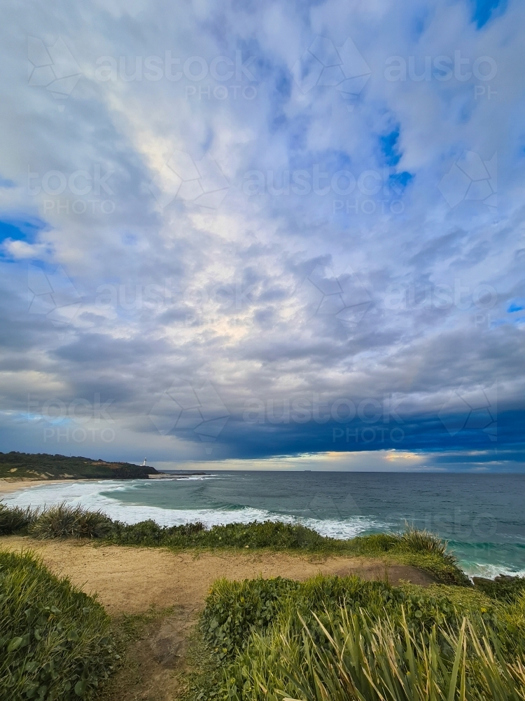 Beach scene with Norah Head Lighthouse in the distance on the NSW Central Coast - Australian Stock Image