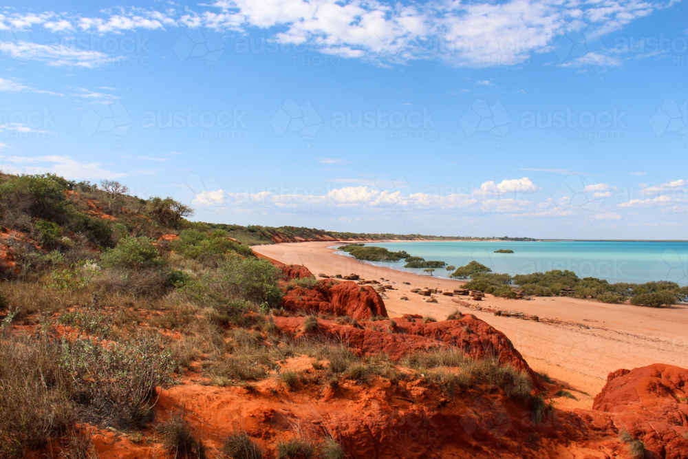 Beach with red cliffs, red sand, and aqua water - Australian Stock Image