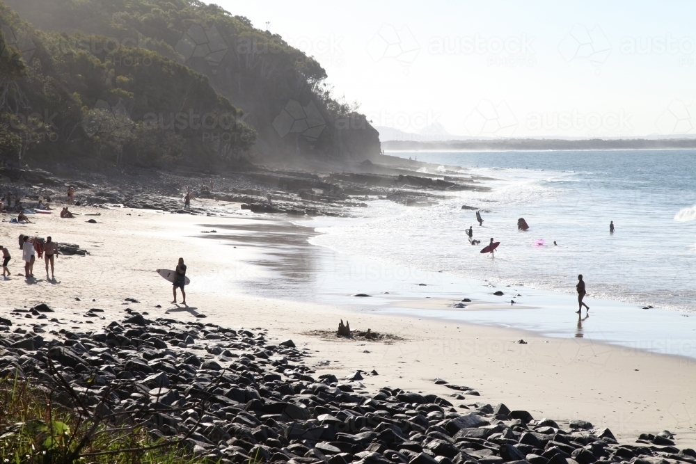 Beach with surfers and people in the distance - Australian Stock Image