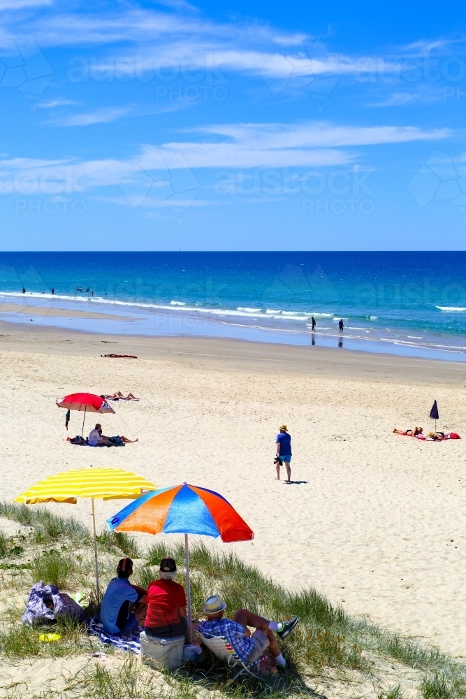 Beachgoers enjoying summer at Coolum Beach, Sunshine Coast, Queensland - Australian Stock Image