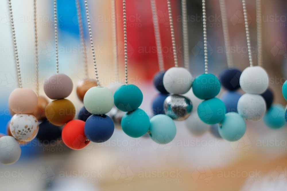Beaded necklaces hanging at a market stall - Australian Stock Image