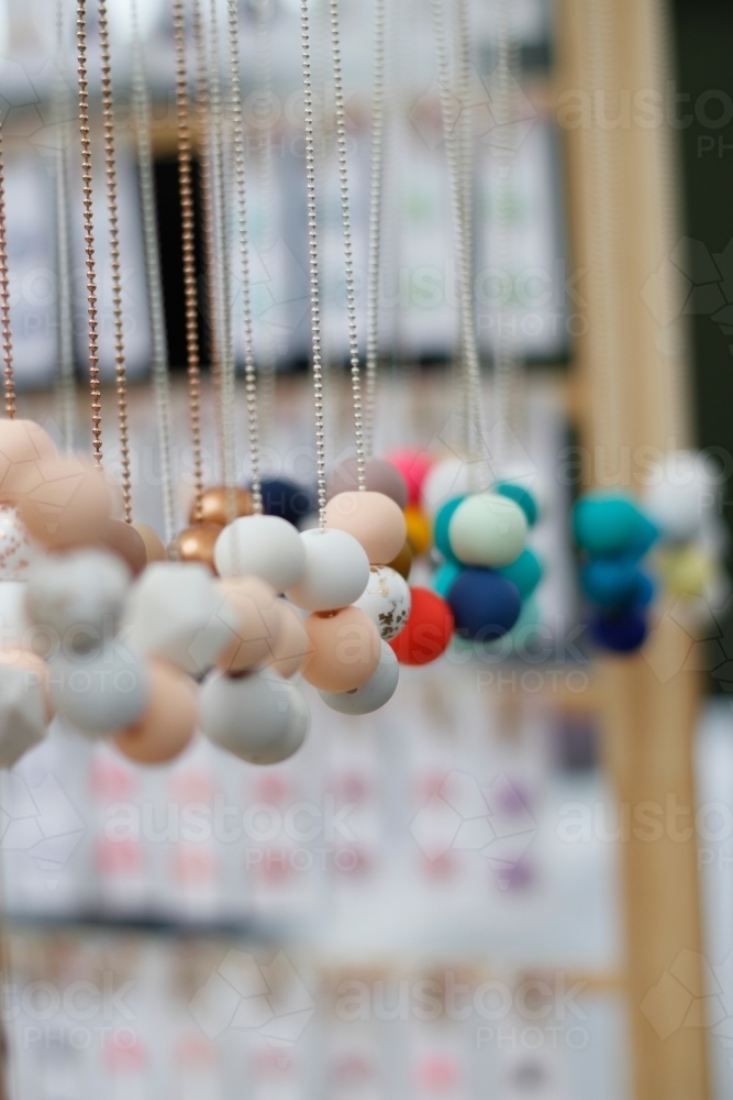 Beaded necklaces hanging at a market stall - Australian Stock Image