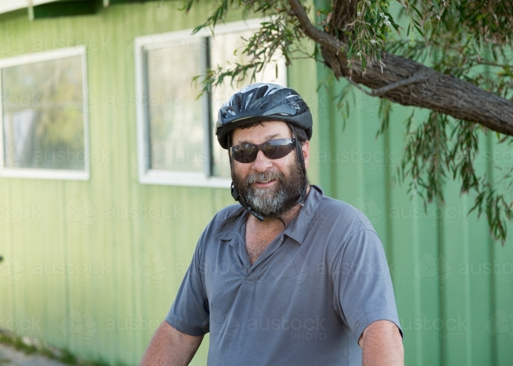 Bearded man wearing a bicycle helmet outdoors - Australian Stock Image