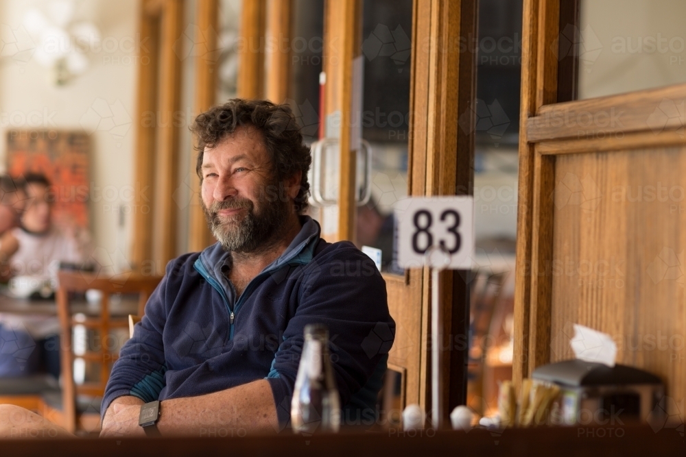 Bearded middle aged man sitting in a cafe - Australian Stock Image