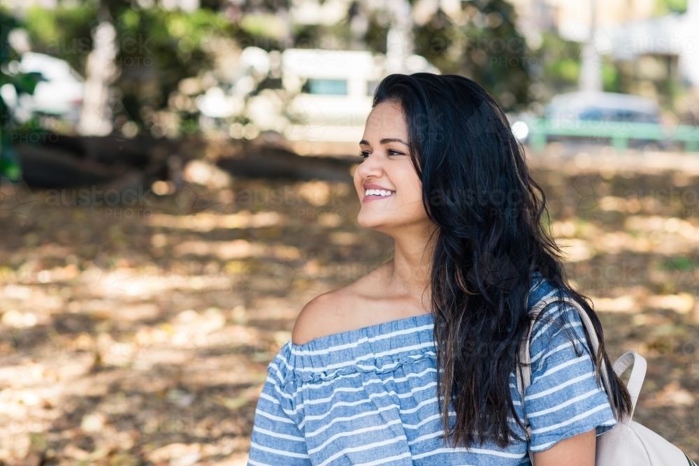 beautiful indian woman in a park - Australian Stock Image