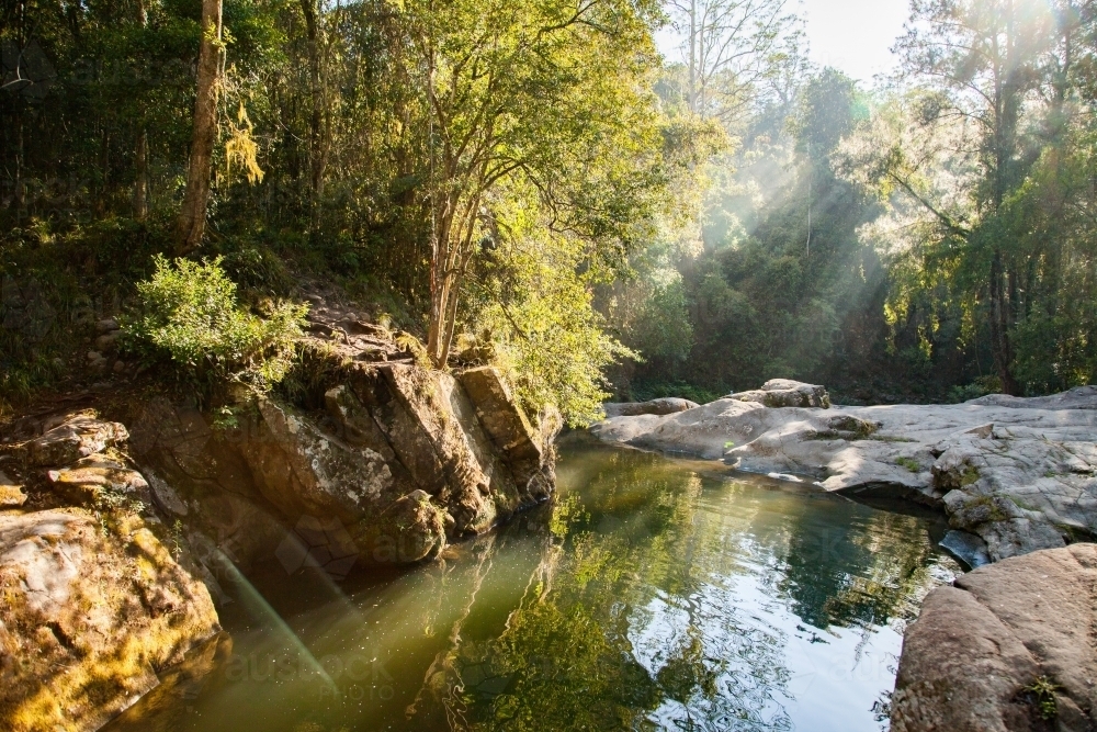 Image of Beautiful quiet scenery with sun flare over Ladies Well, Allyn River Austockphoto