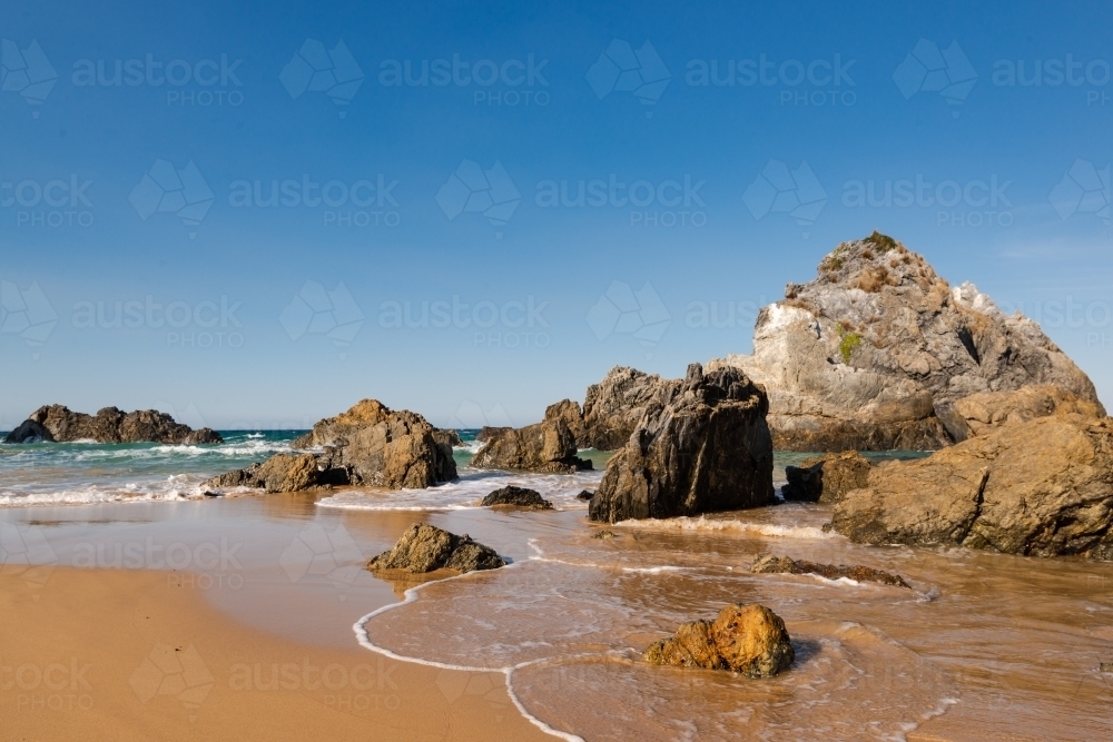 Beautiful Rocky beach and shore scene with clear blue sky - Australian Stock Image