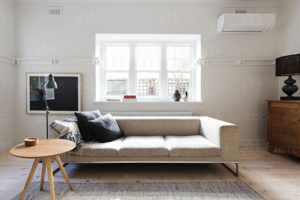 Beautifully styled interior living room of sofa and coffee table in a renovated apartment - Australian Stock Image