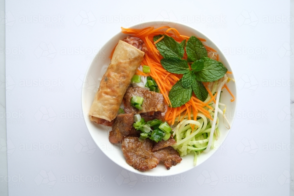 Beef noodle salad topped with fried lumpia - Australian Stock Image