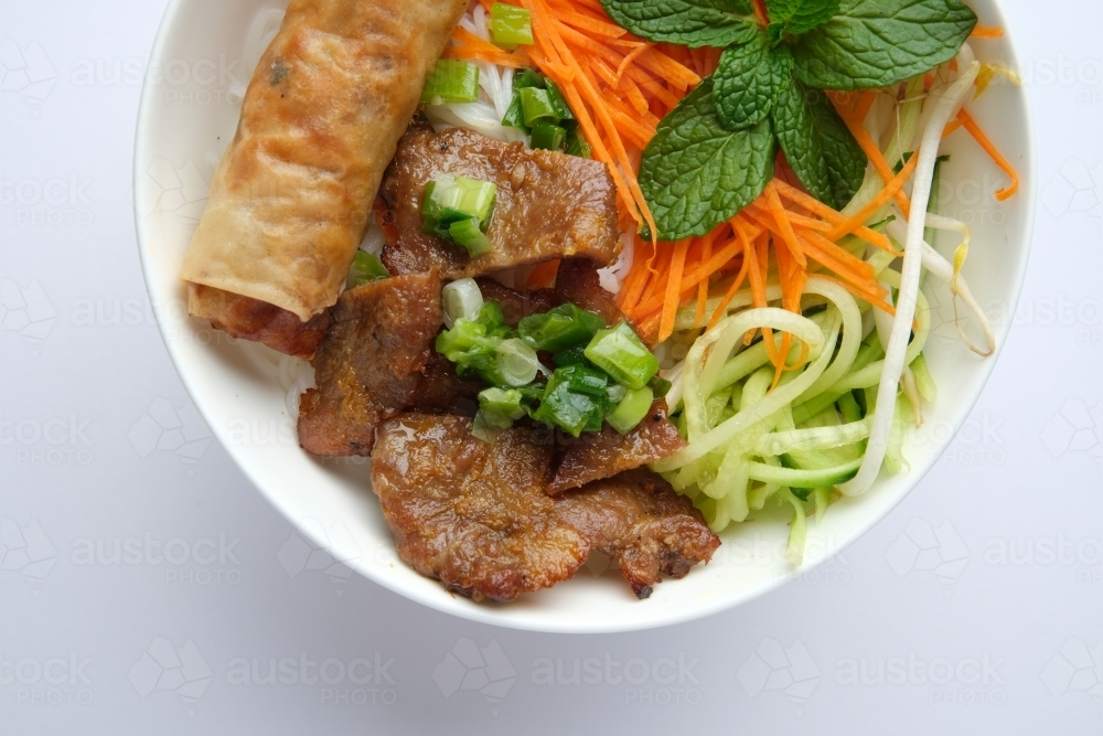 Beef noodle salad topped with fried lumpia - Australian Stock Image