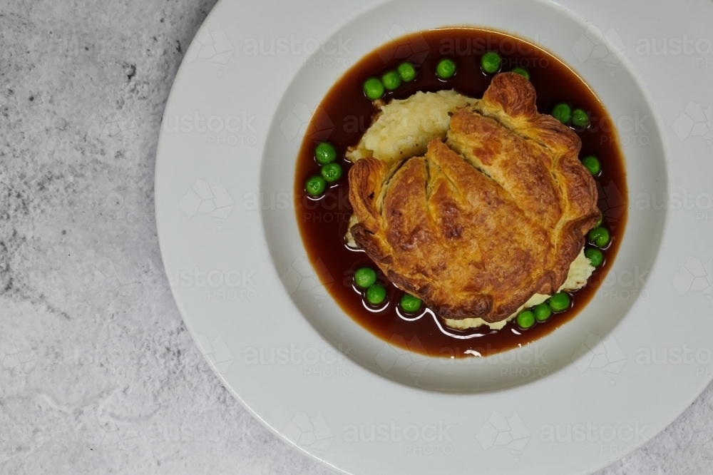 Image Of Beef Pie On Mashed Potato Peas And Gravy Austockphoto image-of-beef-pie-on-mashed-potato-peas-and-gravy-austockphoto