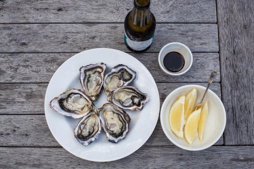 beer and oysters on outdoor table - Australian Stock Image