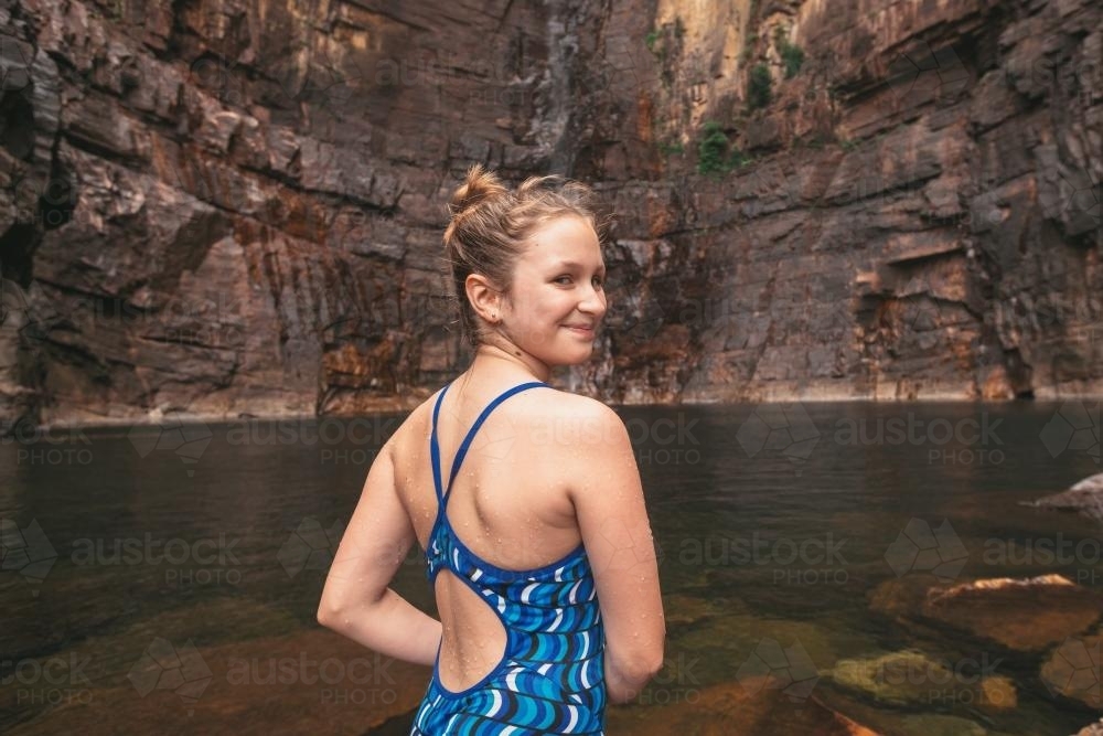 behind view of teen girl at a waterhole in a national park - Australian Stock Image