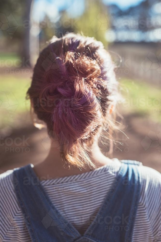 behind view of teenager with purple colour in her hair - Australian Stock Image
