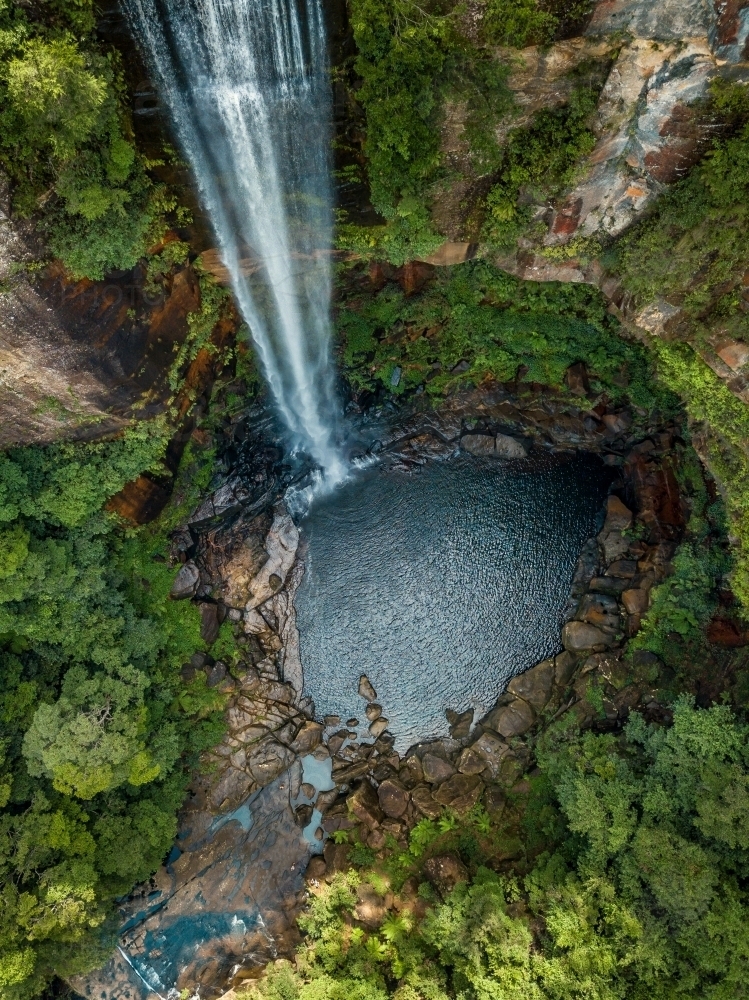 Belmore Falls as it drops over sheer cliffs into blue pool - Australian Stock Image