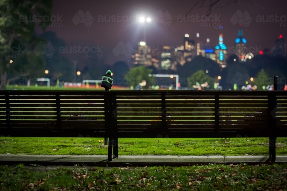 Bench seat at a sports ground with city in the background - Australian Stock Image