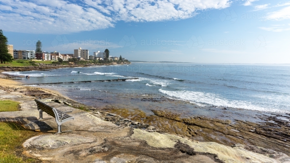 Bench seat overlooking ocean and pool - Australian Stock Image