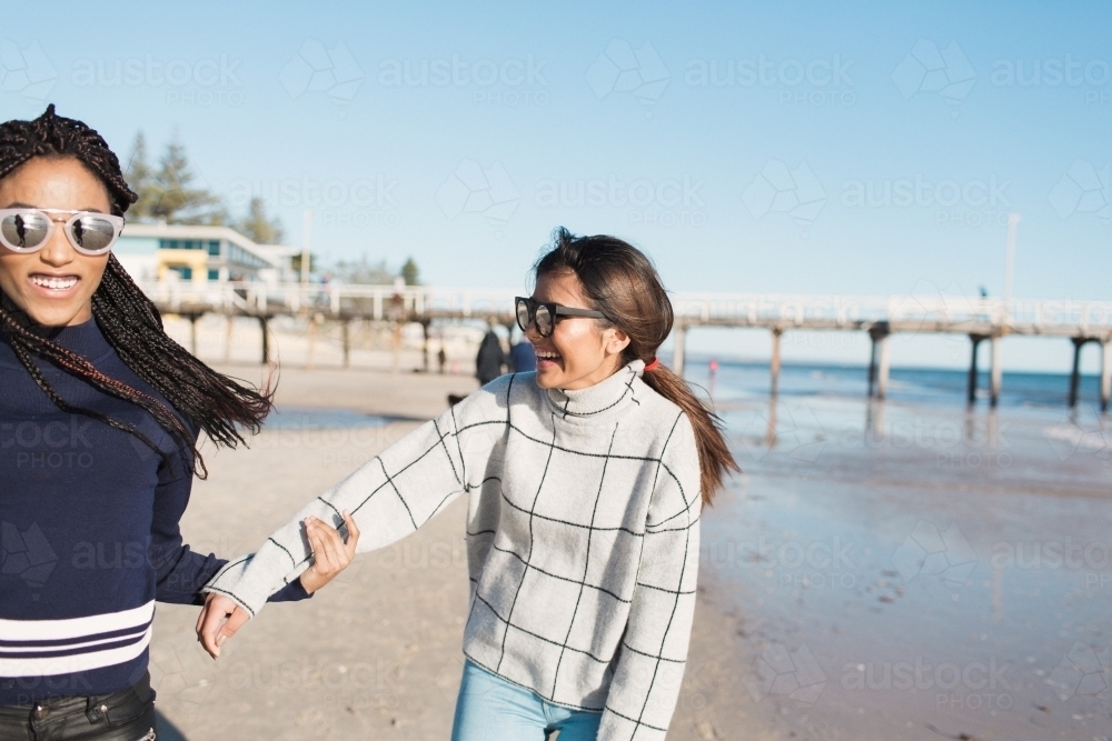 Best friends spending time on the beach laughing - Australian Stock Image