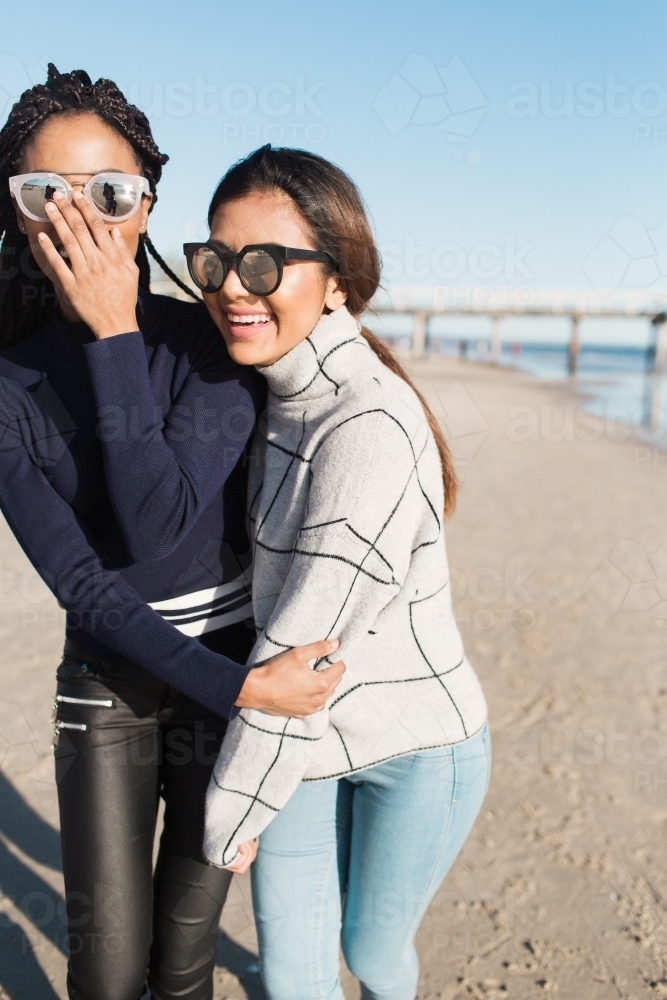 Best friends spending time on the beach laughing - Australian Stock Image
