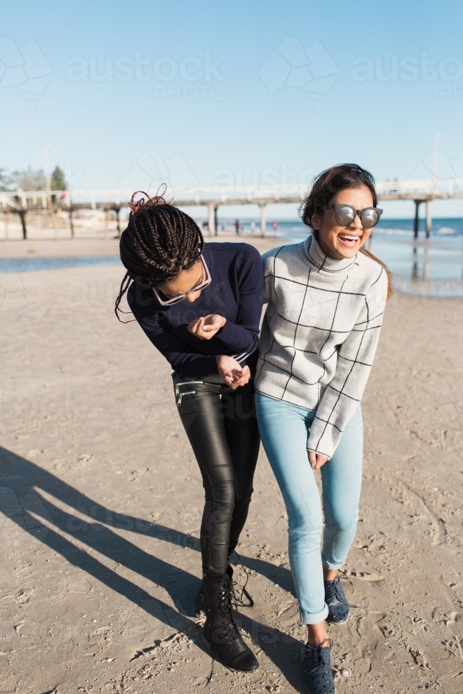Best friends spending time on the beach laughing - Australian Stock Image