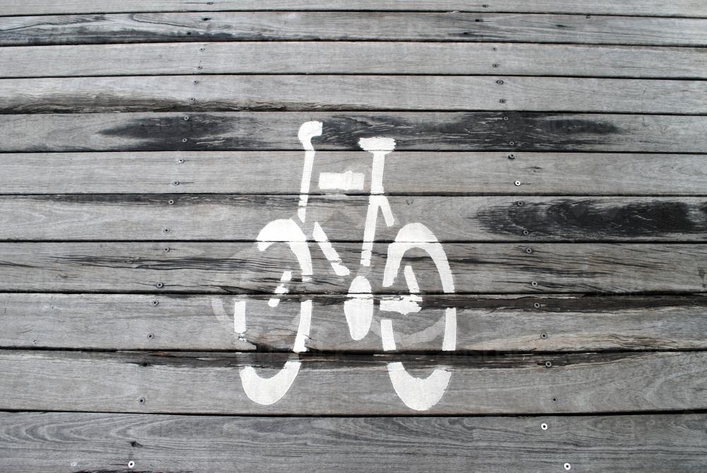 Bicycle sign in white paint on wooden boardwalk - Australian Stock Image