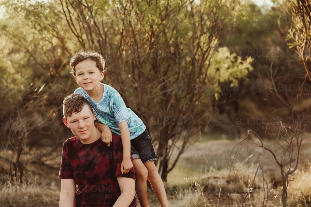 Big and little brother mucking around in the Australian bush - Australian Stock Image