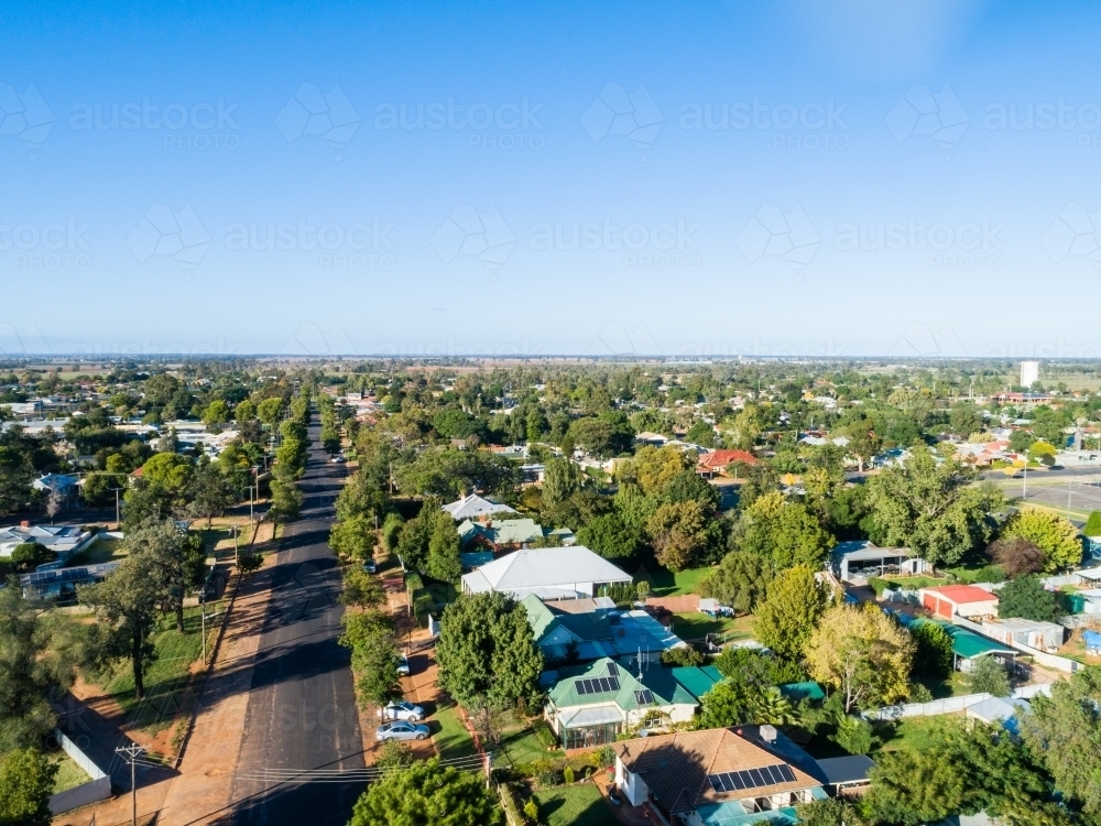 Big blue australian sky over rural town, houses hide amongst trees - Australian Stock Image