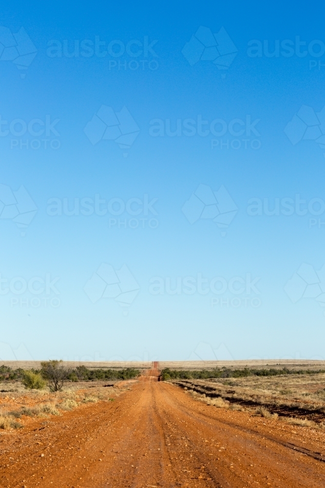 Big blue sky with red dirt road in the outback - Australian Stock Image