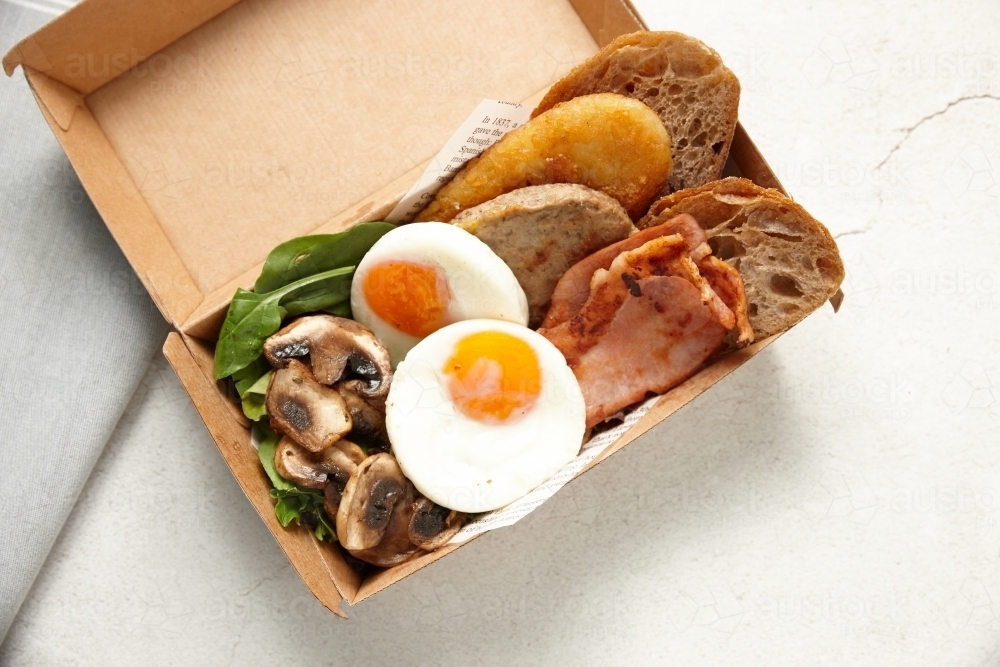 big breakfast in a box composed of eggs, toast, tomato, mushroom and greens - Australian Stock Image