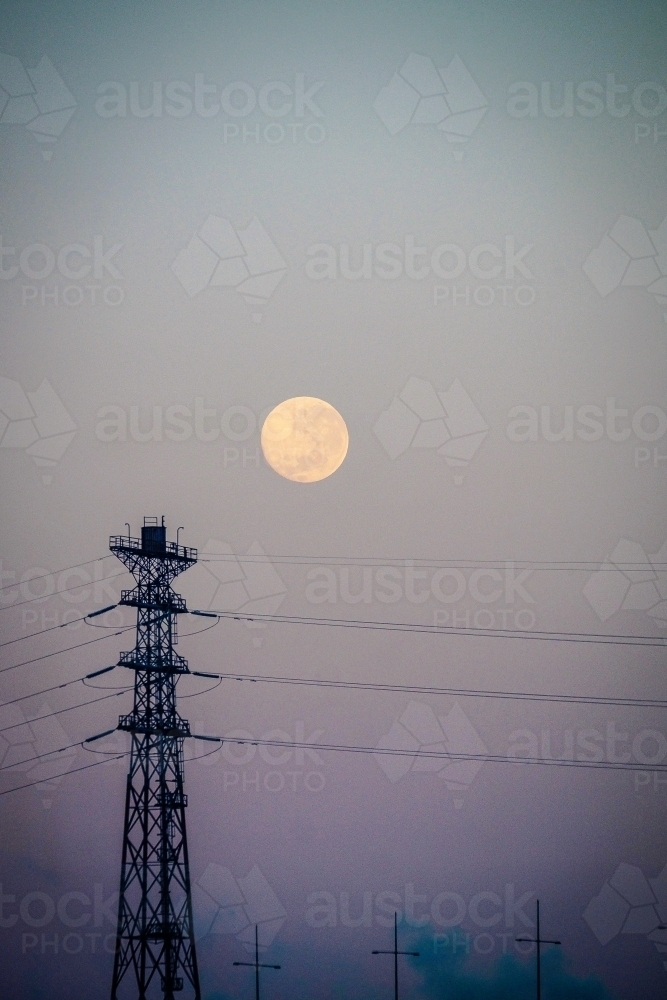 Big moon and a city sky with power lines. - Australian Stock Image
