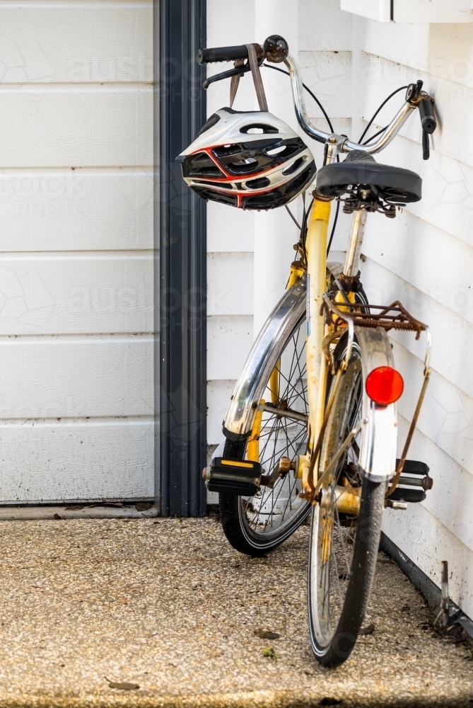 Bike and helmet leaning on the house. - Australian Stock Image