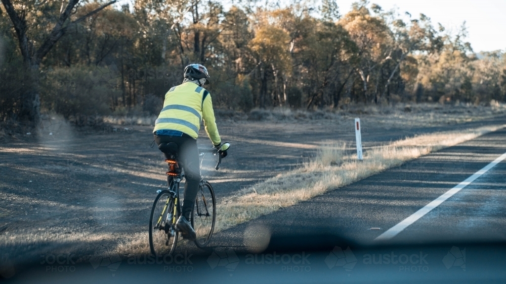 Bike rider alongside country highway - Australian Stock Image