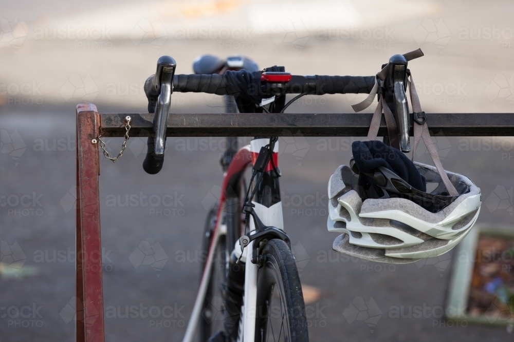 Bike sitting on rack with helmet hanging off handlebar - Australian Stock Image