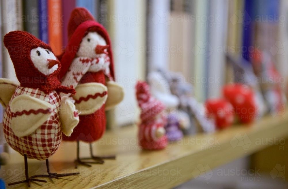 Bird dolls as Christmas decorations on a bookshelf - Australian Stock Image