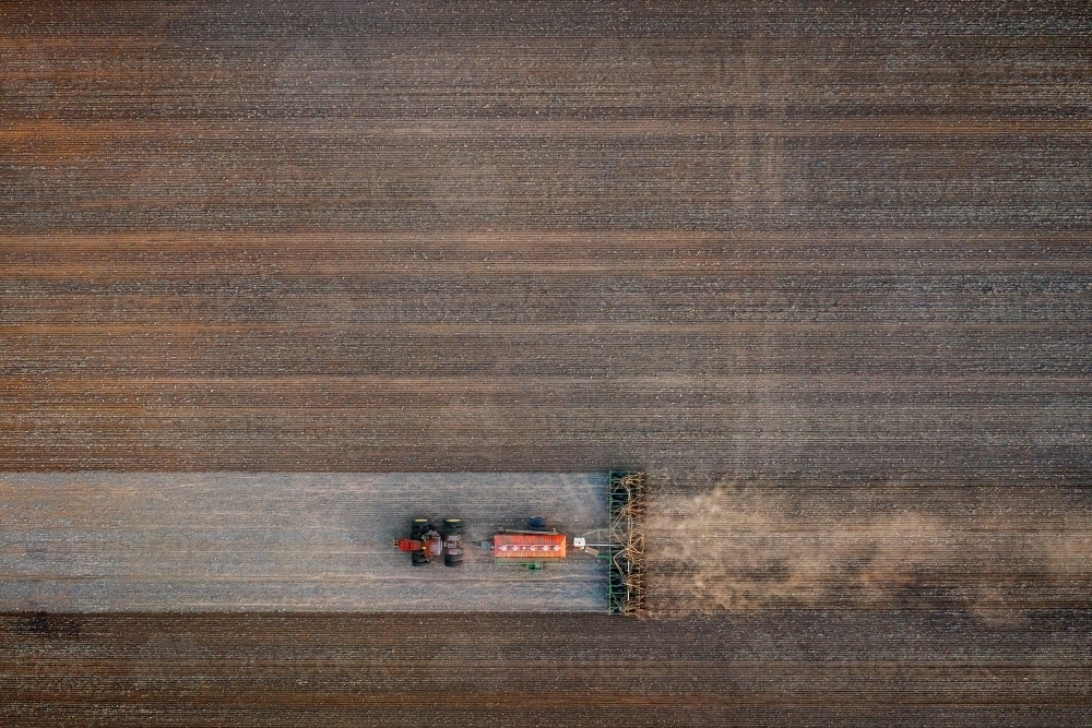 Birds eye view of tractor seeding a dusty paddock - Australian Stock Image
