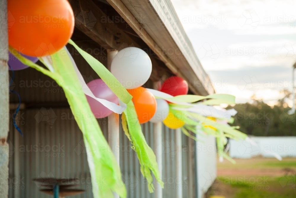 Birthday balloons tied along shed verandah - Australian Stock Image