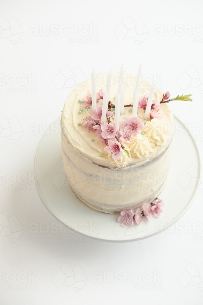 Birthday cake with candles and flowers. - Australian Stock Image